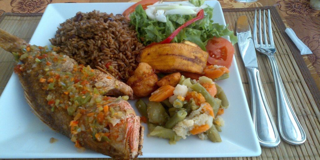 Freshly cooked whole fish served with seasoned rice, salad, fried plantains and mixed vegetables.