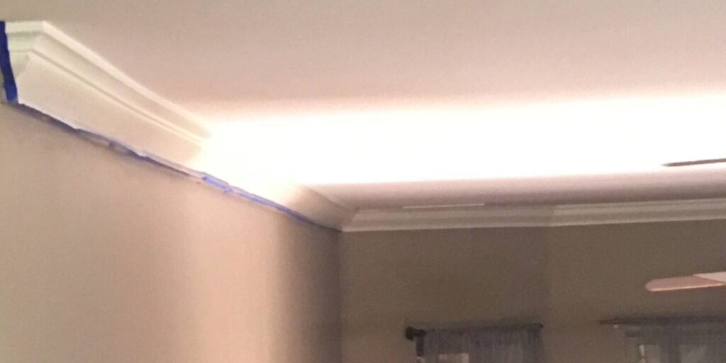 LED strip lighting enhancing corner of room during renovation, with window blinds in background.