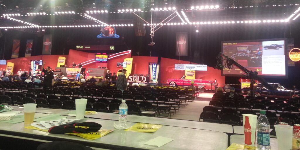 Professionally organized Mecum live car auction in a spacious, well-lit venue.
