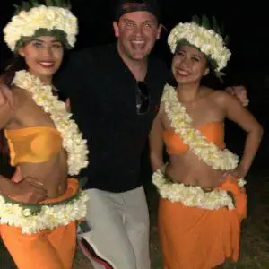 Man enjoying cultural luau with traditional Polynesian performers in Hawaii at night