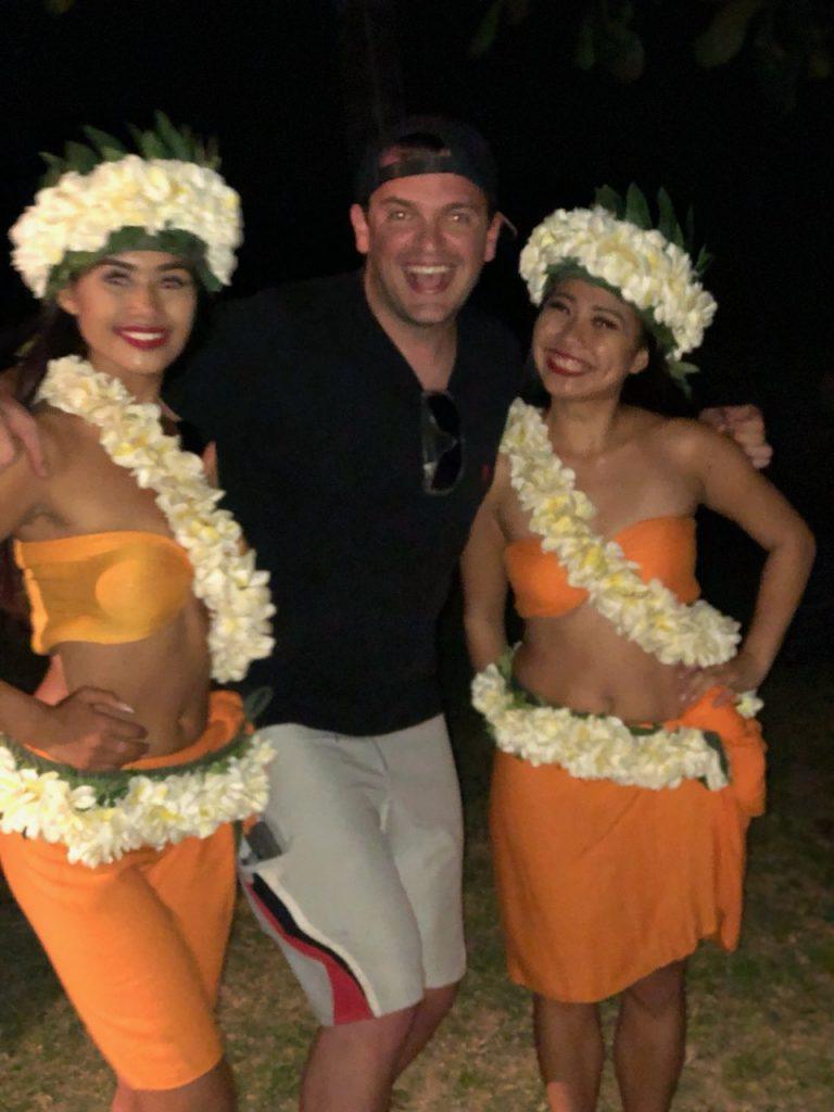 Man enjoying cultural luau with traditional Polynesian performers in Hawaii at night