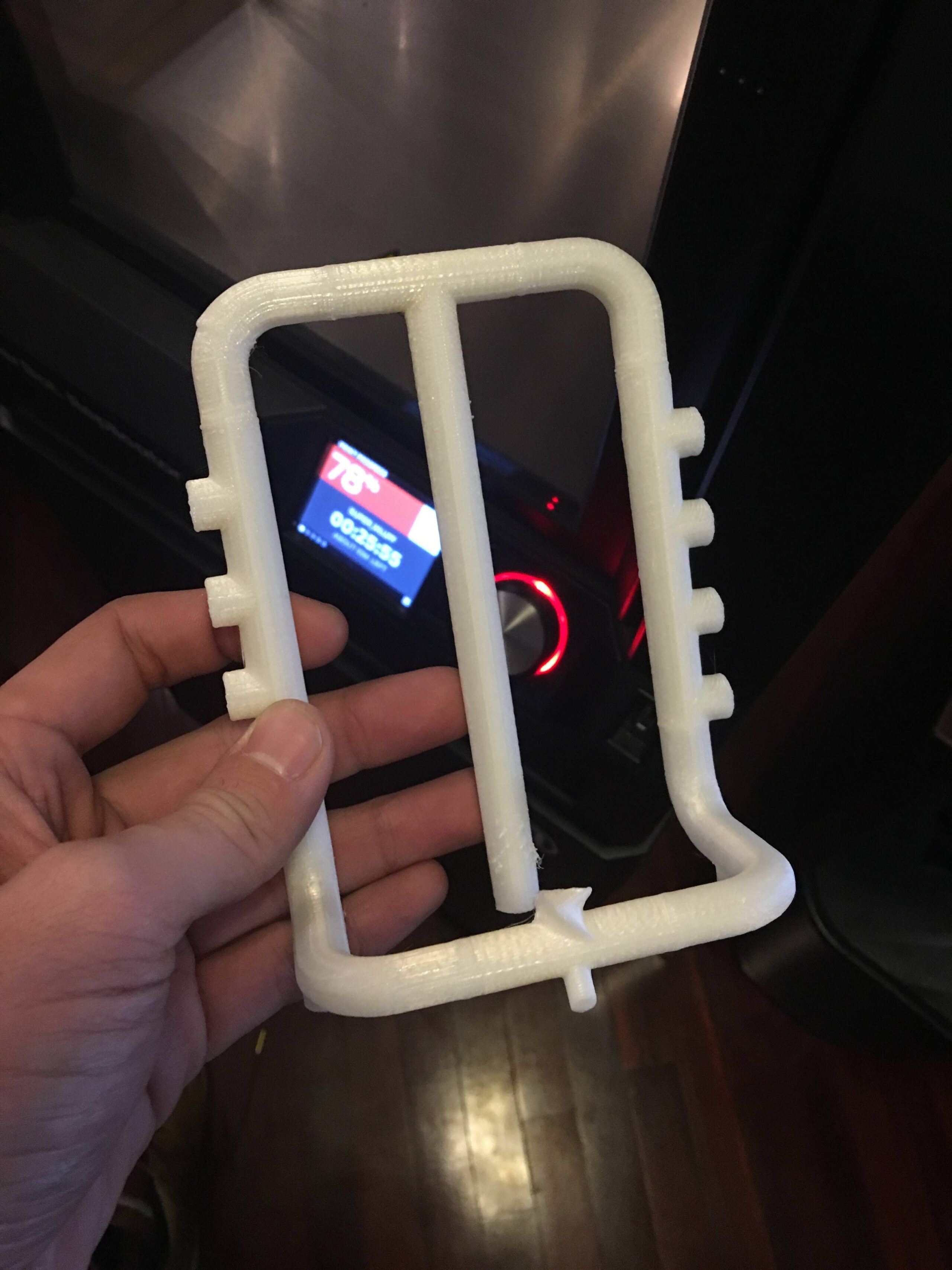 Hand holding a white 3D Print of a digital beverage handle.
